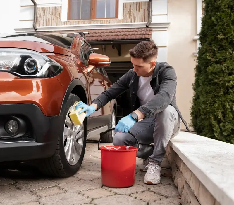 Lavage auto à domicile Le Gué-de-Longroi : professionnel intervenant sur un véhicule
